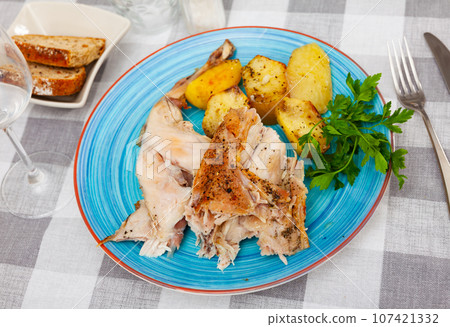 Baked potatoes with roasted rabbit and fresh greens Baked potatoes with roasted rabbit and fresh greens 107421332