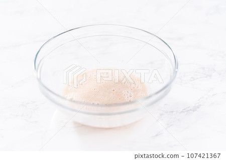 Activating an instant yeast in a glass mixing bowl. 107421367