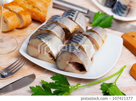 Slices of lightly salted mackerel with greens at plate 107421377