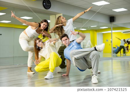 Team of teenagers dancing modern dances in studio Team of teenagers dancing modern dances in studio 107421525