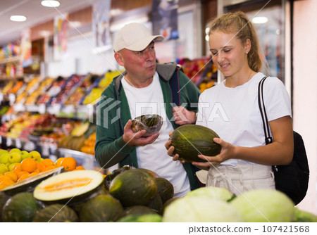 Man with a fifteen-year-old girl choose melons 107421568