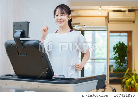 使用跑步機訓練的女性 使用跑步機訓練的女性 107421889
