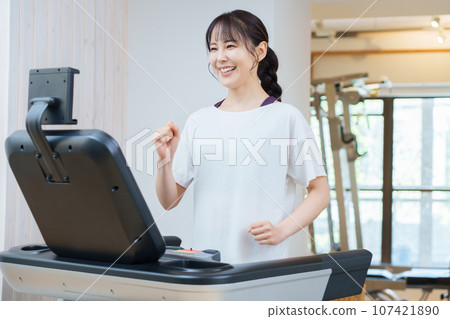 A woman training using a treadmill 107421890