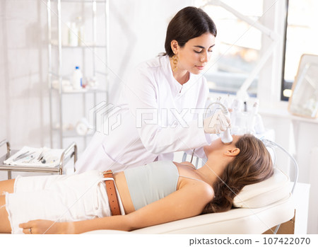 Female doctor making facial beauty massage with vibration attachement Female doctor making facial beauty massage with vibration attachement 107422070
