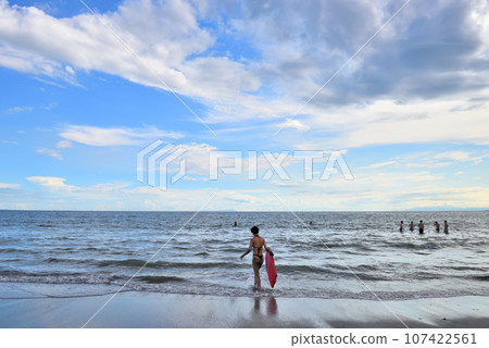 Female bodyboarder standing on the beach Female bodyboarder standing on the beach 107422561