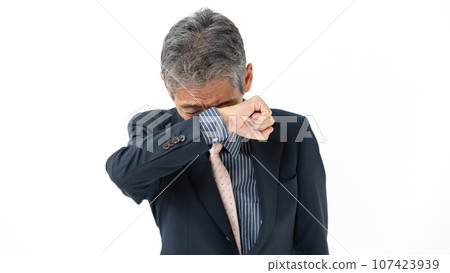 一位年長的商人摀著臉哭泣 一位年長的商人摀著臉哭泣 107423939