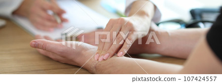 Doctor checkups patient pulse on wrist in medical office Doctor checkups patient pulse on wrist in medical office 107424557