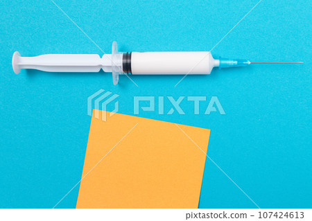 Vaccination or Revaccination Concept - A Medical Syringe on Blue Table 107424613