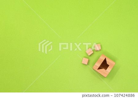 黃綠色背景,顯示從木立方體中發出的輕微聲音,上面標有揚聲器。 黃綠色背景,顯示從木立方體中發出的輕微聲音,上面標有揚聲器。 107424886