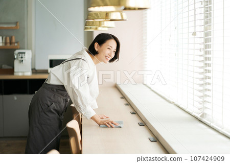 Cafe worker cleaning Cafe worker cleaning 107424909