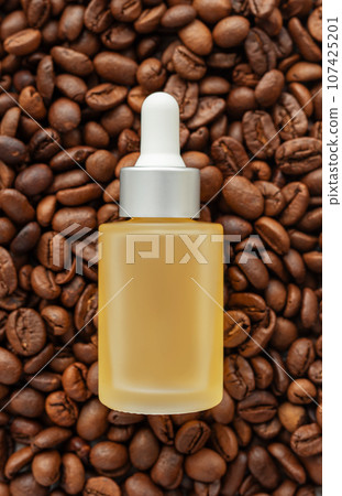 Skincare caffeine eye serum. Product bottle and coffee beans. Skincare caffeine eye serum. Product bottle and coffee beans. 107425201