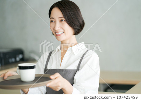 A female clerk serving coffee 107425459