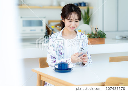 A young woman operating a smartphone 107425578