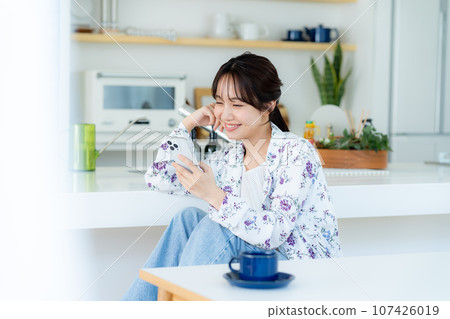 A young woman operating a smartphone A young woman operating a smartphone 107426019