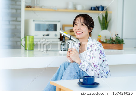A young woman operating a smartphone 107426020