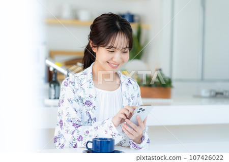 A young woman operating a smartphone A young woman operating a smartphone 107426022