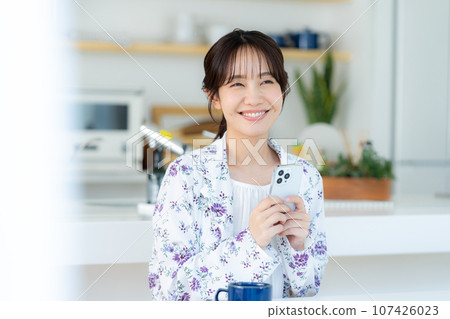A young woman operating a smartphone 107426023