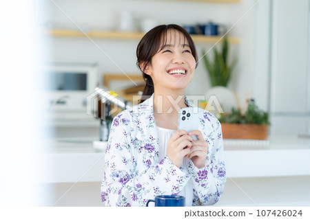 A young woman operating a smartphone 107426024