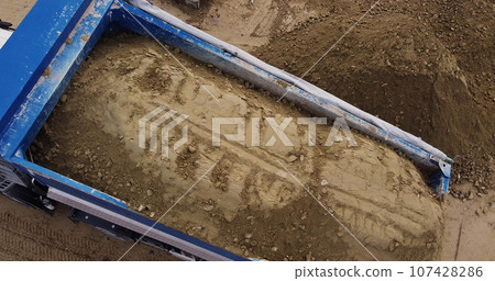 Dump truck unloading soil or sand at construction site. Dump truck unloading soil or sand at construction site. 107428286
