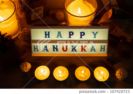Four Candles with advent calendar Lightbox with text HAPPY HANUKKAH Traditional Burning Christmas Wax Candles with numbers counting down for Christmas. Beautiful Advent At Home. Festive Candlelight Four Candles with advent calendar Lightbox with text HAPPY HANUKKAH Traditional Burning Christmas Wax Candles with numbers counting down for Christmas. Beautiful Advent At Home. Festive Candlelight 107428723