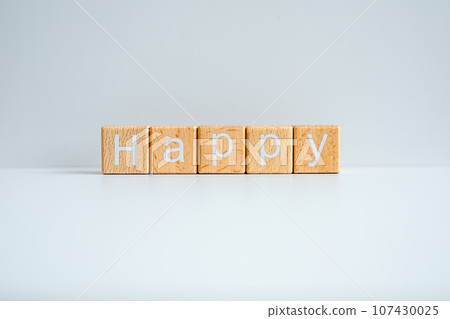 Wooden blocks form the text "Happy" against a white background. 107430025