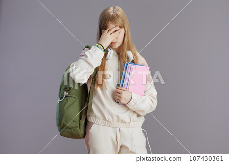 stressed trendy teenager girl in beige tracksuit with backpack stressed trendy teenager girl in beige tracksuit with backpack 107430361