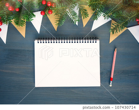 Top view of Christmas background with blank open notepad, pencil and christmas decorations 107430714