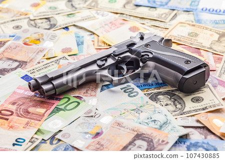 Handgun on various banknotes background. Handgun on various banknotes background. 107430885