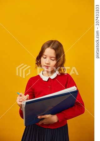 Thoughtful School teenage girl holding pen and write on notebook 107431833