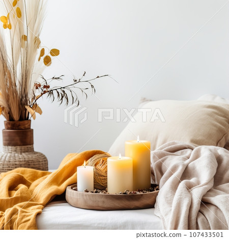 Bright light yellow and white cozy autumn interior decor arrangement, fall home decorations with candles and warm blanket, white wall copy space Bright light yellow and white cozy autumn interior decor arrangement, fall home decorations with candles and warm blanket, white wall copy space 107433501