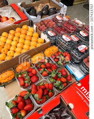 Fresh fruits lie in boxes on the counter at the vegetable market Fresh fruits lie in boxes on the counter at the vegetable market 107433707