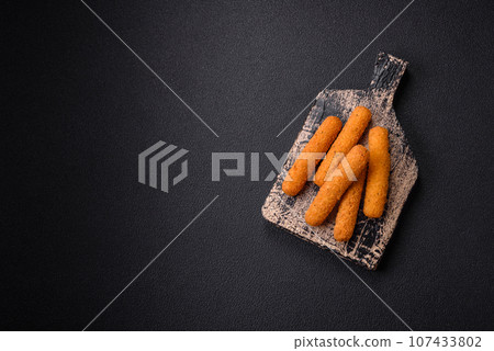 Delicious crispy cheese sticks with mozzarella, salt and spices, breaded and fried in oil Delicious crispy cheese sticks with mozzarella, salt and spices, breaded and fried in oil 107433802