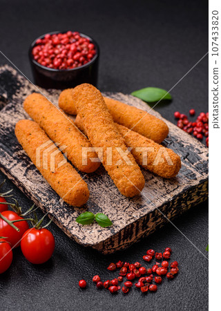Delicious crispy cheese sticks with mozzarella, salt and spices, breaded and fried in oil Delicious crispy cheese sticks with mozzarella, salt and spices, breaded and fried in oil 107433820