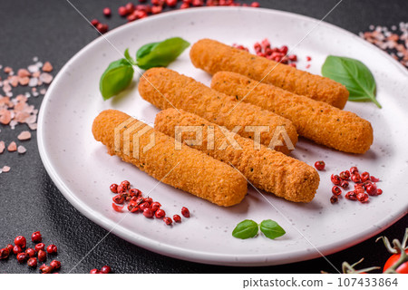 Delicious crispy cheese sticks with mozzarella, salt and spices, breaded and fried in oil 107433864