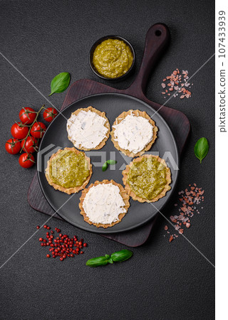 Round snacks with crispy chips or crackers with cream cheese and pesto Round snacks with crispy chips or crackers with cream cheese and pesto 107433939