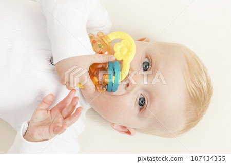 portrait of a little baby playing with a toy 107434355