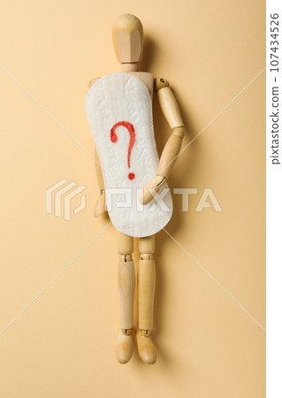 Menstrual cycle concept, wooden figurine of a man holding a pad Menstrual cycle concept, wooden figurine of a man holding a pad 107434526