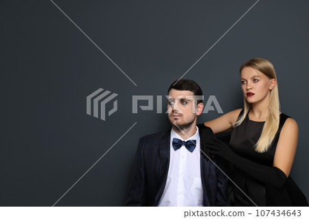 A woman and a man in Halloween costumes on a dark background 107434643