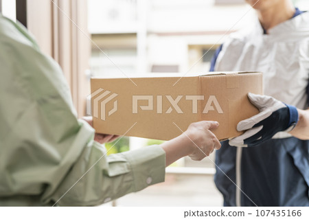 Delivery man in his 40s delivering a package 107435166
