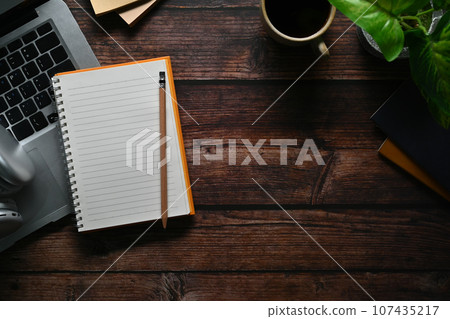 Top view of notepad, laptop computer and headphone wooden table. Space for your text 107435217