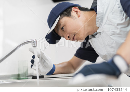 A male worker inspecting the faucet 107435244
