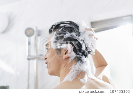 一名40多歲的男子在浴缸裡洗頭 一名40多歲的男子在浴缸裡洗頭 107435303