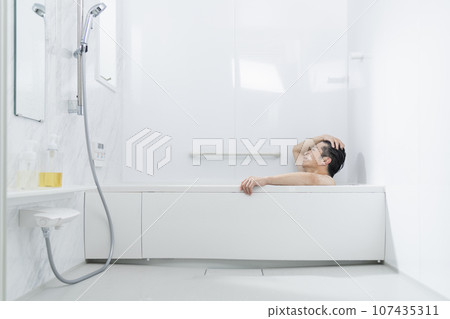 一名 40 多歲的男子在浴缸裡放鬆 一名 40 多歲的男子在浴缸裡放鬆 107435311