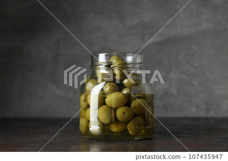 Olives in jar on gray background, close up 107435947