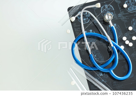 MRI or magnetic resonance imaging of head and brain with stethoscope and pills. Place for text 107436235