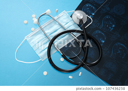 MRI or magnetic resonance imaging of human brain with stethoscope and pills. Top view 107436238