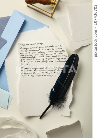 Blue envelopes, sheets of paper, bird feather and letter with text on white background, top view Blue envelopes, sheets of paper, bird feather and letter with text on white background, top view 107436702
