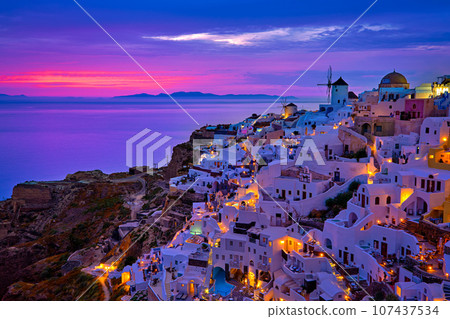 Beautiful view of Oia village with traditional whitewashed houses and windmills, Santorini island, at sunset, Greece. Scenic travel background, famous destination, colorful sky and clouds. Beautiful view of Oia village with traditional whitewashed houses and windmills, Santorini island, at sunset, Greece. Scenic travel background, famous destination, colorful sky and clouds. 107437534