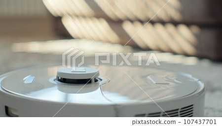 Close-up hands of woman opens tank of robot vacuum cleaner after cleaning and takes out container of garbage at home. Robotic device for house cleaning, professional cleaning. Close-up hands of woman opens tank of robot vacuum cleaner after cleaning and takes out container of garbage at home. Robotic device for house cleaning, professional cleaning. 107437701