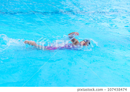 child swimmer swim in swimming pool. Water sports training and competition, learning to swim classes for children 107438474